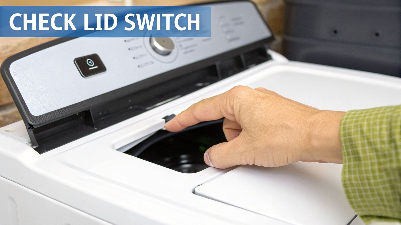 A person's hand points to the black lid switch of an open white top-load washing machine.